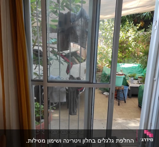 תריסים לבנים על דלת זכוכית עם סורגים